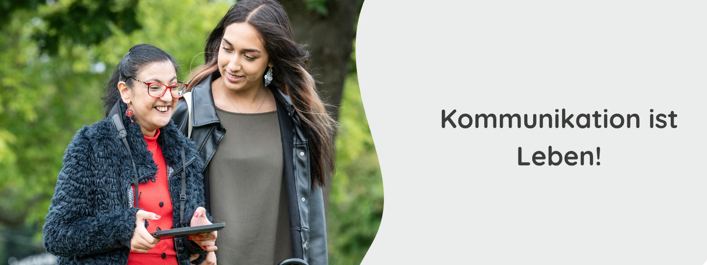 Zwei junge Frauen sitzen vor einem Sprachcomputer